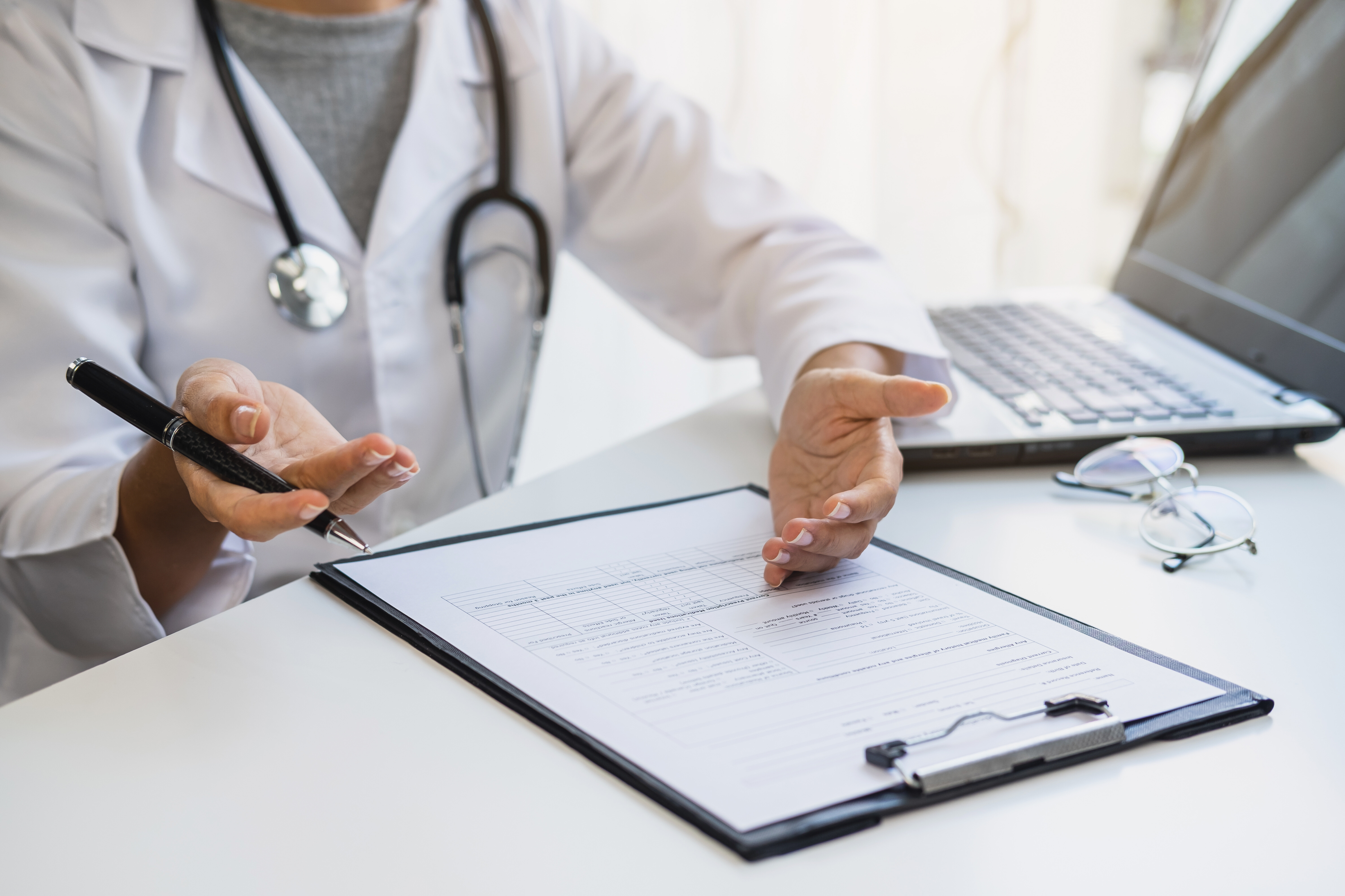 physician writing on form