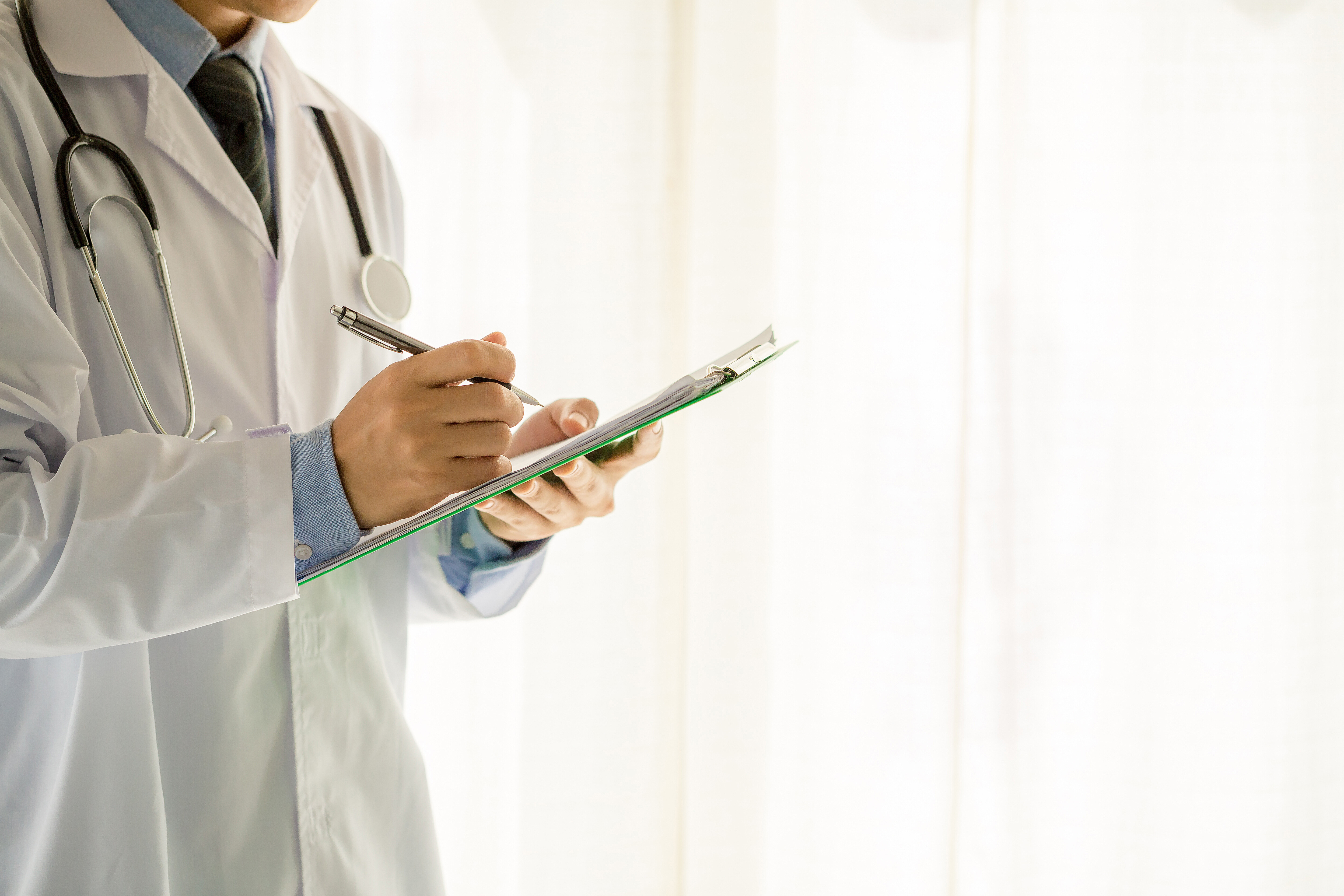 medical physician writing on a clipboard